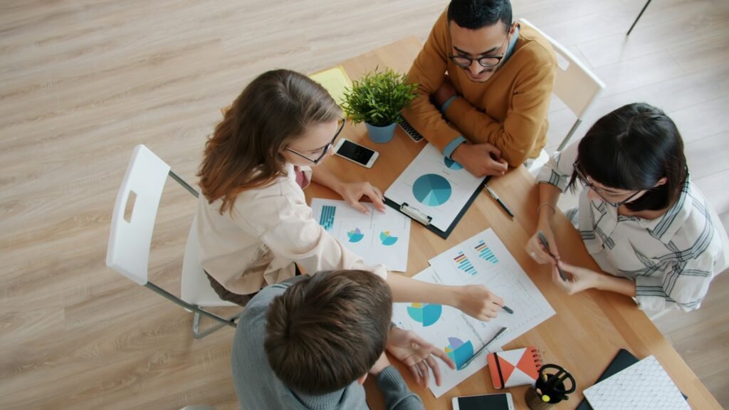 Team collaborating around a table with charts