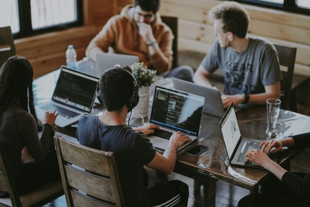Software development team working together on laptops